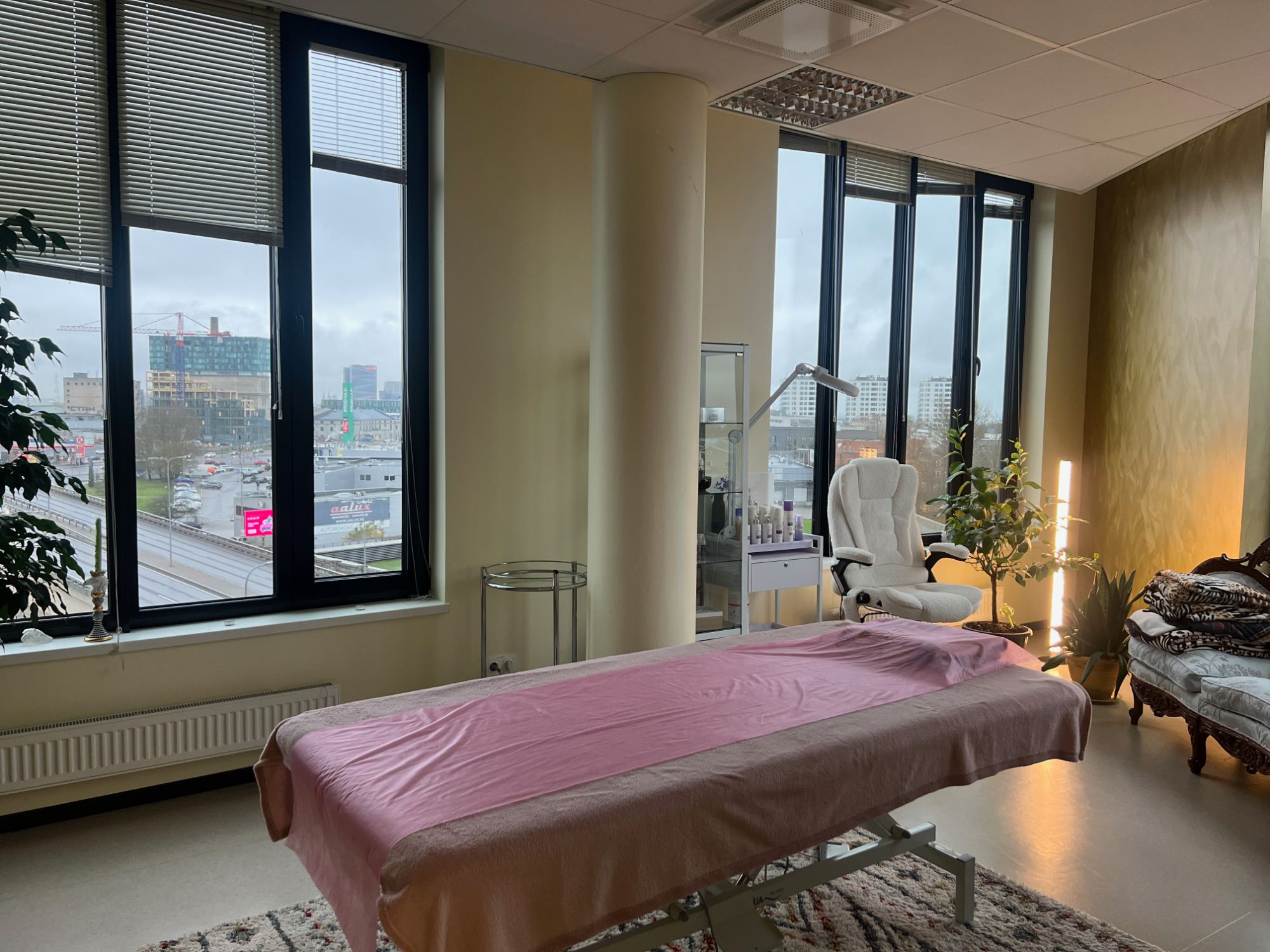 Valgusküllane vastuvõturuum suurte akende ja linnavaatega, Osteopaatia Butiik Tallinnas